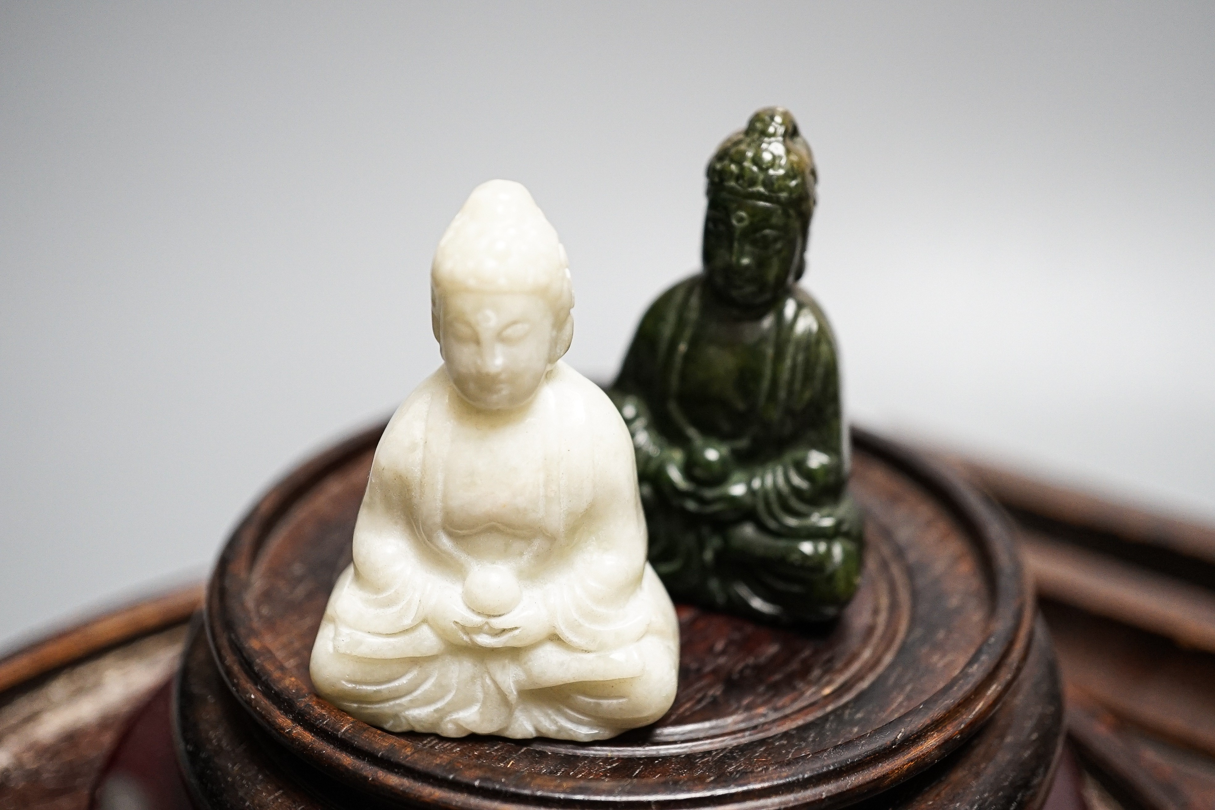 A pair of hard stone vases, 2 hard stone figural carvings, a porcelain elephant, and a quantity of hardwood stands